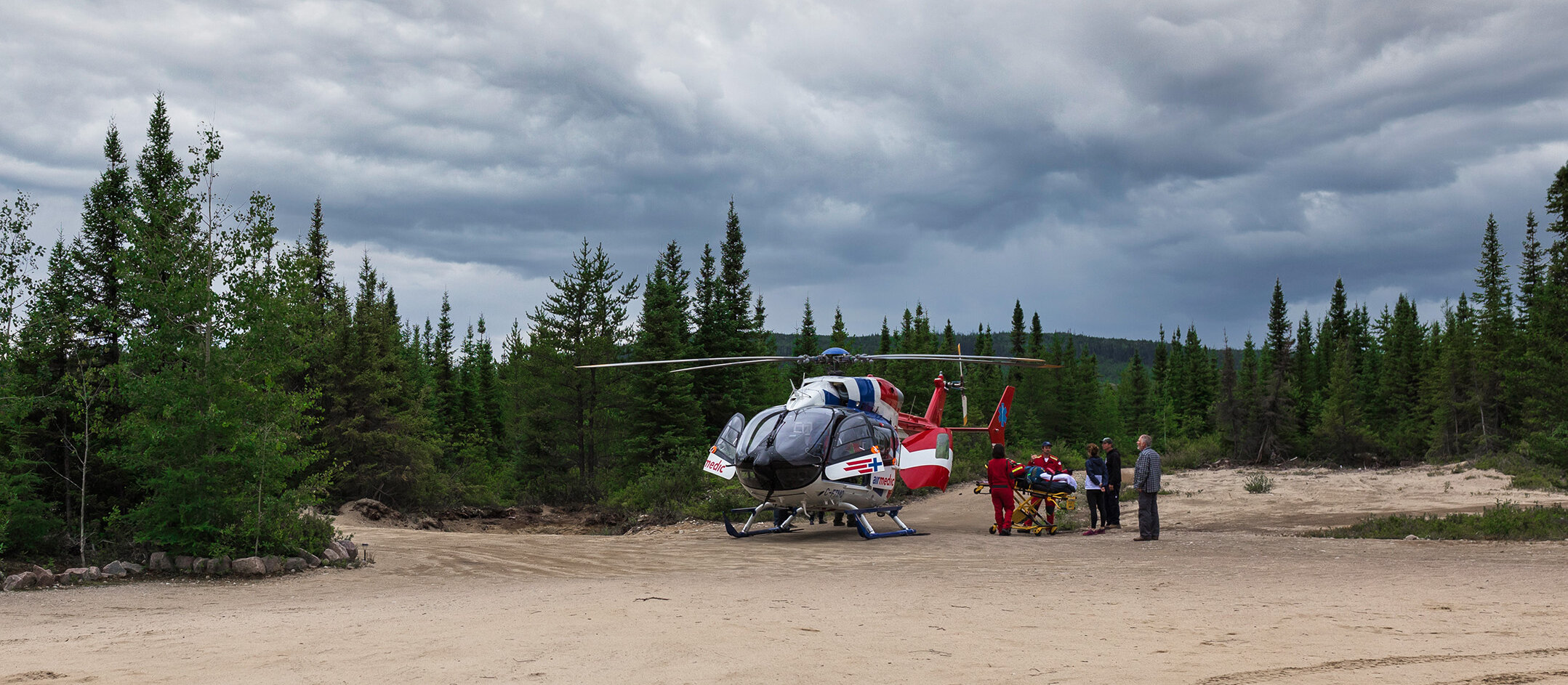 Un cri du cœur pour tous les chasseurs – le témoignage de Dany Guénette présenté par CAA Le 4 septembre 2021, Dany Guénette et 10 partenaires de chasse se rendent dans le secteur de Parent en Mauricie pour préparer leur saison de chasse. Les VTT sont assurés grâce à CAA, leurs permis de chasse sont en règle, et ils ont tout le matériel nécessaire. La dernière étape est d’aller vérifier l’état de leurs miradors, situés à plus de 35 km du chalet. Arrivé à sa cache, Dany grimpe dans l’échelle pour aller inspecter le plancher de la structure et se retrouve face à un nid de guêpes, un insecte dont il est allergique depuis maintes années. Pris de panique, il essaie de redescendre le plus vite possible de l’échelle, mais se fait malencontreusement piquer à deux reprises. Le stress mélangé à la douleur ressentie fait en sorte que Dany perd pied et fait une chute de 15 pieds. À ce moment, il se rend compte qu’il n’a plus aucune sensation au bas du corps et sent la réaction allergique se développer petit à petit. Dany et ses amis lancent un cri du cœur aux chasseurs, aux pêcheurs et à tous individus fréquentant des régions éloignées au Québec à la suite de son accident survenu à l’automne 2021. « Je peux vous jurer qu’Airmedic c’est important. Que ce soit vous ou l’un de vos amis qui est par terre, vous allez vous en rappeler pour le restant de votre vie. Vous avez la chance de prendre votre protection Airmedic, prenez-la. » Mike, ami de Dany Les avantages d’une évacuation aérienne Allongé au sol, Dany a 2 vertèbres fracturées dont une éclatée en trois morceaux faisant pression sur la moelle épinière en plus d’avoir une fracture au poignet gauche. Seul, il attend 45 minutes dans la panique et la douleur qu’un de ses amis vienne à son secours. Son ami, Carl Guénette, qui le trouve au sol, a le réflexe de s’emparer de l’Epipen qui se trouve sur le VTT de Dany, à 20 mètres de lui. Heureusement, la réaction allergique est contrôlée. Ensuite, Carl part chercher de l’aide. Il a 1 h 30 de route à faire avant de revenir au chevet de son compagnon qui, durant ce temps, reste par terre. Carl revient plus rapidement que prévu avec des renforts. Son cousin, Tony Paradis, a sa formation de premier répondant. En apercevant Dany au sol, ce dernier voit immédiatement que sa colonne vertébrale est affectée. Une escorte routière n’est donc pas envisageable. Pour lui, la solution est simple, il faut appeler Airmedic. À deux, ils utilisent des morceaux de bois afin de concevoir une planche dorsale pour être en mesure de bouger le blessé. Si Dany avait utilisé une évacuation terrestre, sa fracture aux vertèbres aurait occasionné une lésion de sa moelle épinière, ce qui aurait causé la perte de la force musculaire de ses jambes, des fonctions de l’intestin, de la vessie et la perte de la fonction sexuelle de manière permanente. « Si ce n’était pas d’Airmedic, je ne marcherais plus aujourd’hui. Merci Airmedic. » Dany Guénette Informations à donner à la centrale Airmedic Pendant ce temps, Sébastien Forget, qui se trouve au chalet, appelle l’ambulance. Celle-ci prévoit arriver dans les quatre prochaines heures. Cependant, l’équipe au campement de chasse notifie Sébastien qu’une évacuation routière n’est pas envisageable en raison des blessures de Dany. Une évacuation héliportée est impérative. C’est à ce moment qu’il appelle la centrale de coordination d’Airmedic avec l’aide d’un voisin muni d’un téléphone satellite. Le coordonnateur à la centrale demande beaucoup de renseignements qui, dans le feu de l’action, peuvent être difficiles à donner surtout dans la situation de Dany où Sébastien, qui communique avec la centrale, n’est pas aux côtés du blessé. Il est donc important d’être préparé en amont. Voici la liste des informations pertinentes à communiquer : • Nom du blessé • Nom de la personne qui appelle et numéro de téléphone • Numéro de membre • Nombre de blessés • Description de l’accident • État de santé du blessé • Coordonnées GPS • Identification d’un site d’atterrissage Une fois l’hélicoptère en vol, ils gardent une communication constante toutes les 20 minutes afin de s’assurer que l’état de santé de Dany ne chute pas dans l’attente du personnel médical. « Quand l’hélicoptère est arrivé, on était les plus heureux sur la planète. » — Jimmy Villeneuve Tout est bien qui finit bien Maintenant, Dany marche et profite de la vie pleinement. Il a encore des efforts à faire pour se déplacer, mais il est sur la bonne voie grâce à des séances de réhabilitation. Sans l’intervention d’Airmedic, sa vie serait complètement différente aujourd’hui. Airmedic, sauver des vies, partout au Québec, en tout temps. 