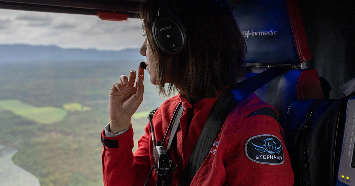 Une femme en helicoptère au dessus des montagnes
